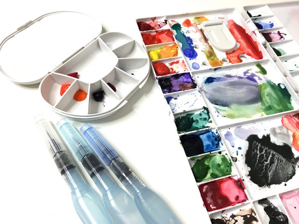 A regular watercolor palette is too large to travel with