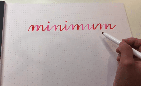 Brush lettering 'minimum' word in pink